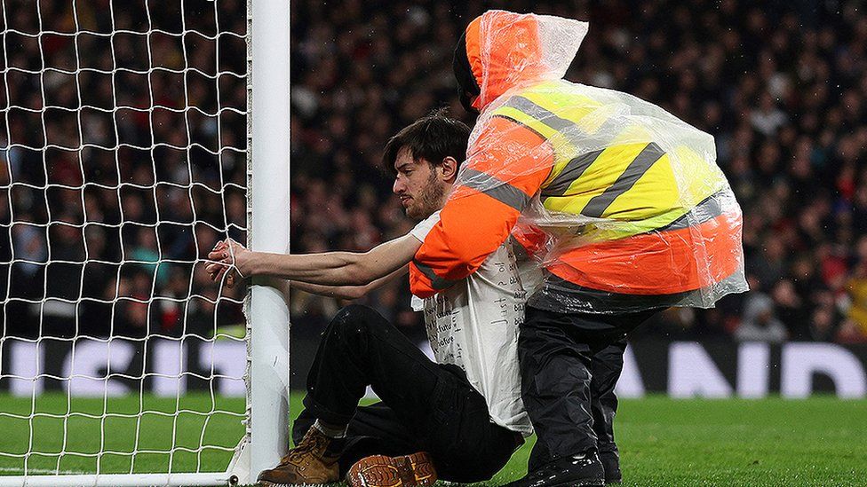 Protester attached to a goalpost during the Arsenal and Liverpool game