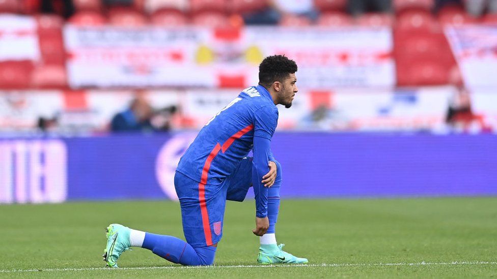 Jadon Sancho of England takes a knee in support of the Black Lives Matter movement ahead of the international friendly match between England and Romania