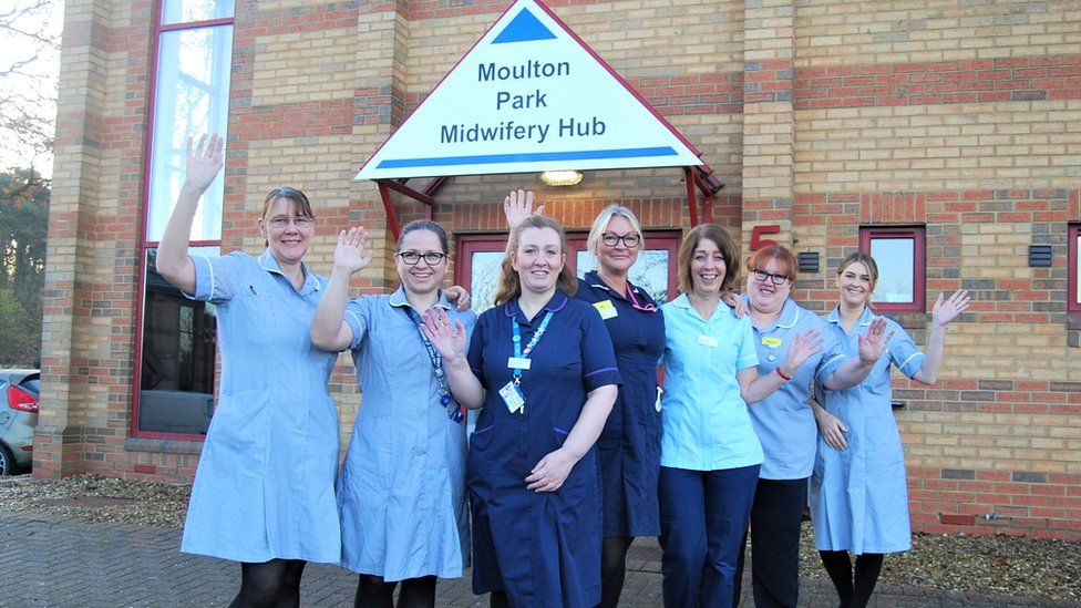 Midwives in blue uniform stand outside new hub