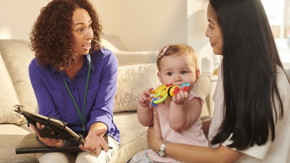 Social worker with a mother and her child