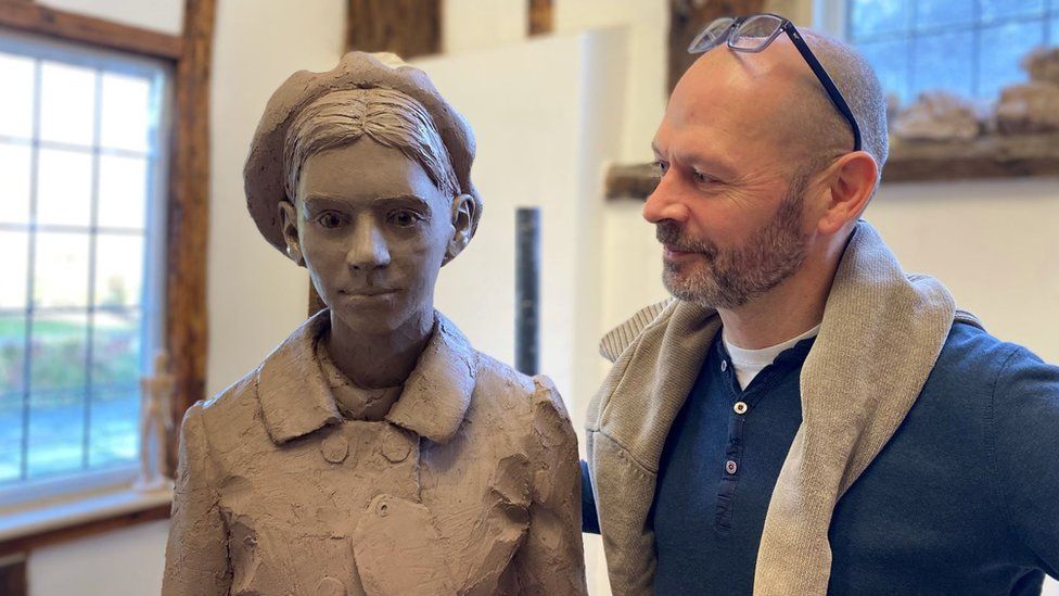 Sculptor Ian Wolter with statue