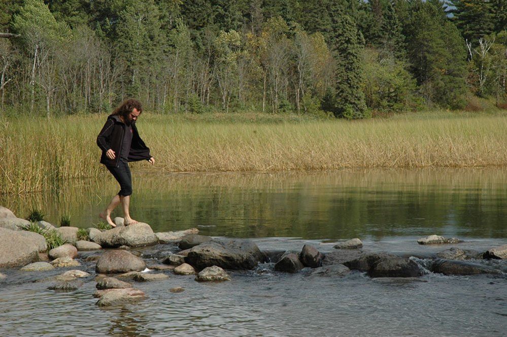 Man crossing a river using stepping stones