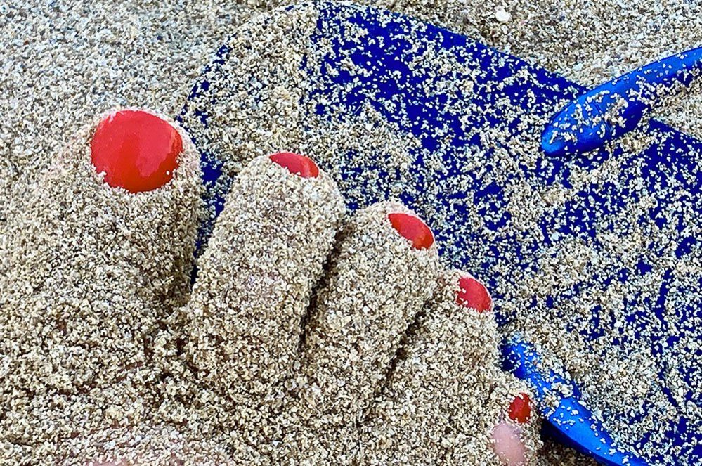Feet covered in sand