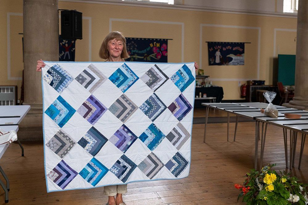 Elaine Andrews holding her patchwork quilt