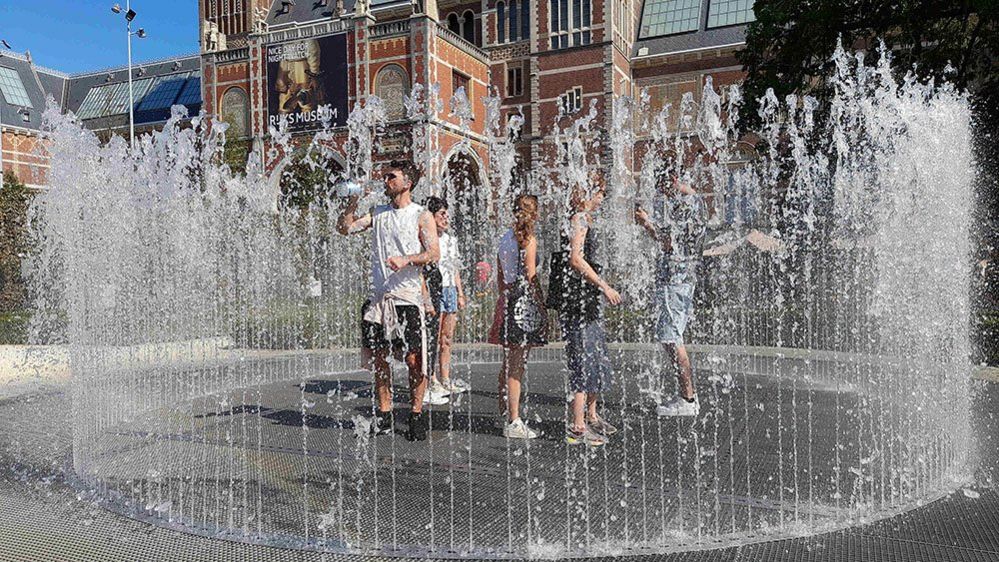 People cooling off in a water fountain