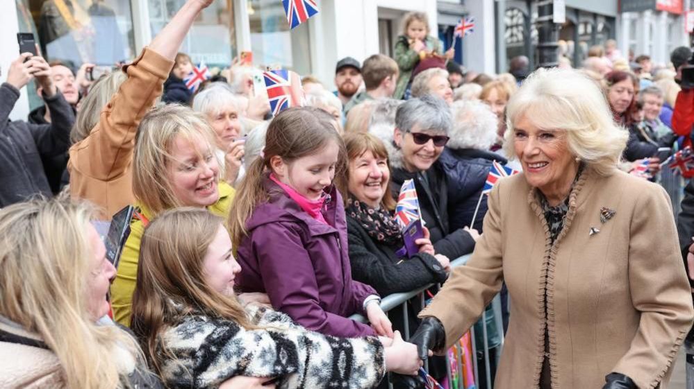 The Queen shakes hands with a young girl