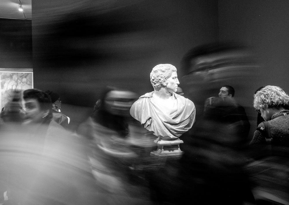 Sculpture surrounded by blurred people
