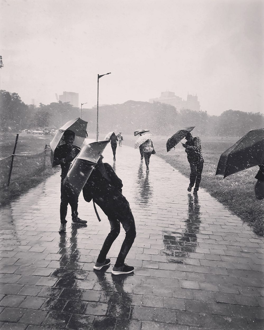 People shelter from the rain under umbrellas