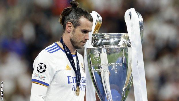 Gareth Bale walks past the Champions League trophy