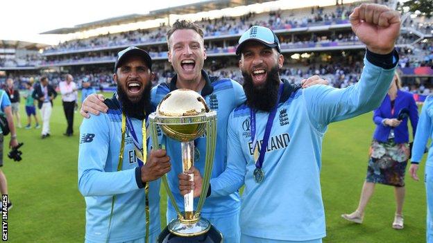 Moeen Ali, Jos Buttler and Adil Rashid celebrate with the trophy after winning the Final of the ICC Cricket World Cup 2019 between New Zealand and England at Lord's Cricket Ground