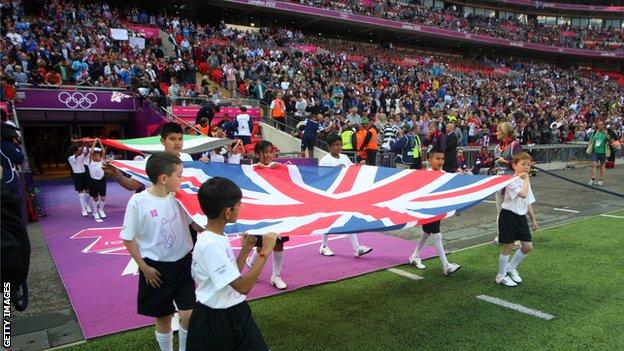 Mascots carry out the union jack flag before Team GB's match at Wembley