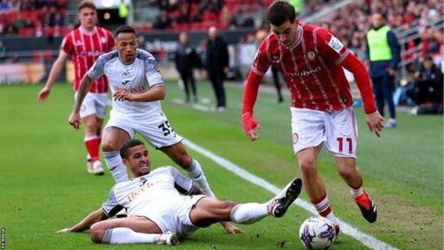 Swansea City's Kyle Naughton attempts to tackle Bristol City's Anis Mehmeti