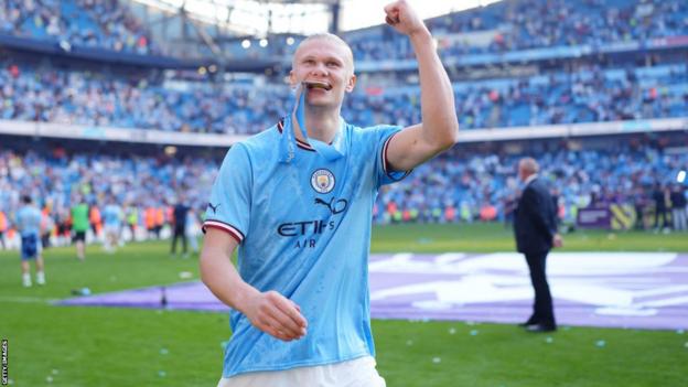 Erling Haaland bites his Premier League medal to celebrate winning the title