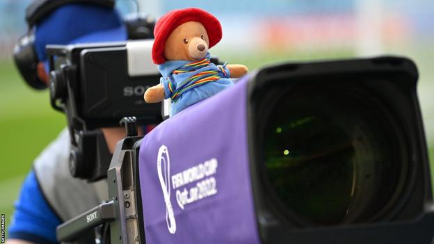 A bear with rainbow laces is seen on top of a broadcast camera during the group match between Denmark and Tunisia