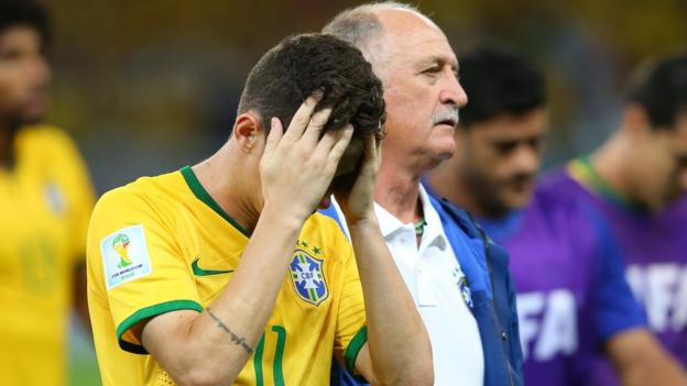Brazil's Oscar is consoled by Luiz Felipe Scolari after the 7-1 defeat by Germany in the 2014 World Cup semi-final