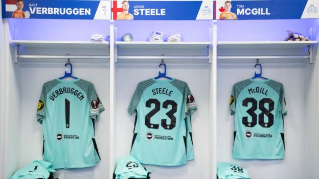 The shirts of Brighton goalkeepers Bart Verbruggen, Jason Steele and Tom McGill in the dressing room at the Amex Stadium before their Europa League tie against Marseille in December