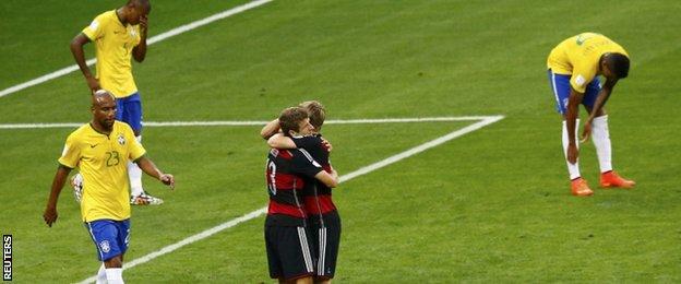 Thomas Muller (left) hugs Toni Kroos with Brazil's players around them