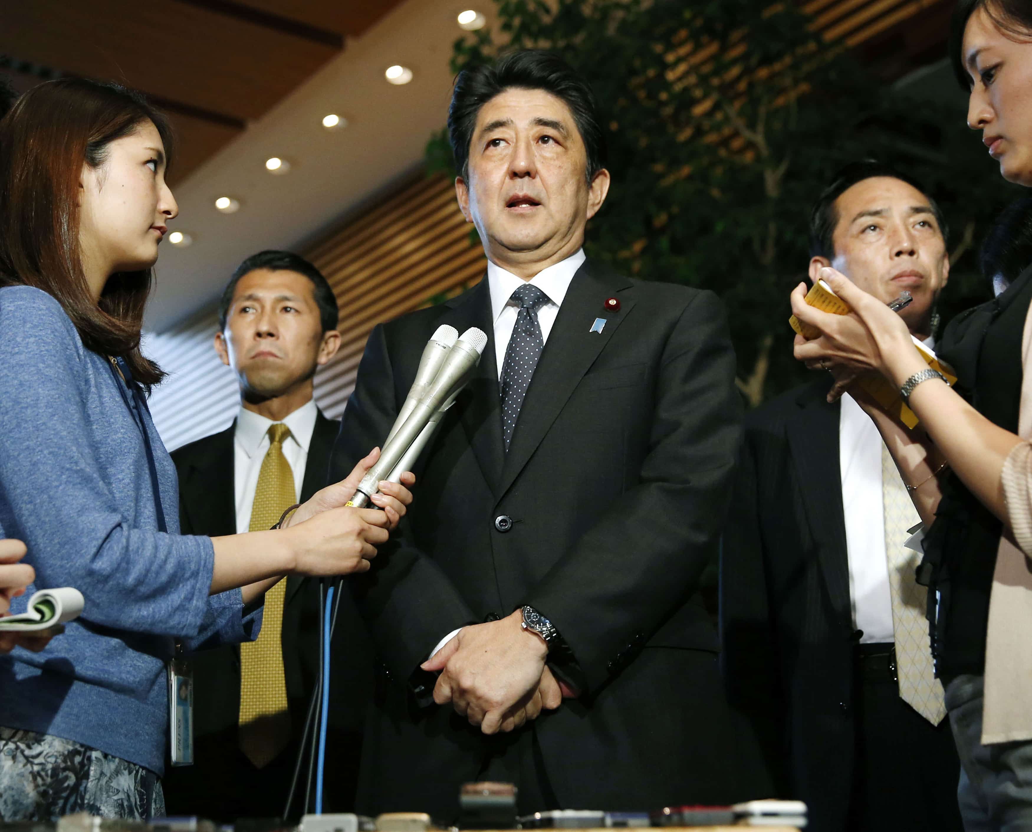 Japan's Prime Minister Shinzo Abe (C) speaks to media at his official residence in Tokyo May 29, 2014, REUTERS/Kyodo