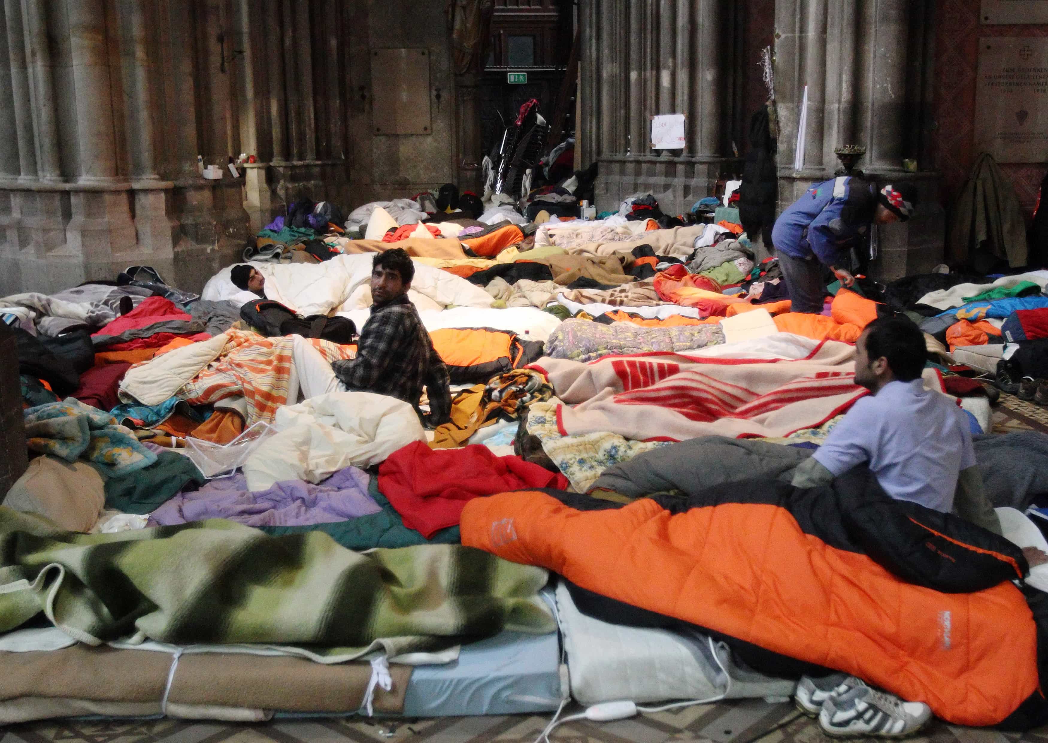 Refugees sit in a mattress camp in Votivkirche church in Vienna, 23 January 2013. , REUTERS/Heinz-Peter Bader