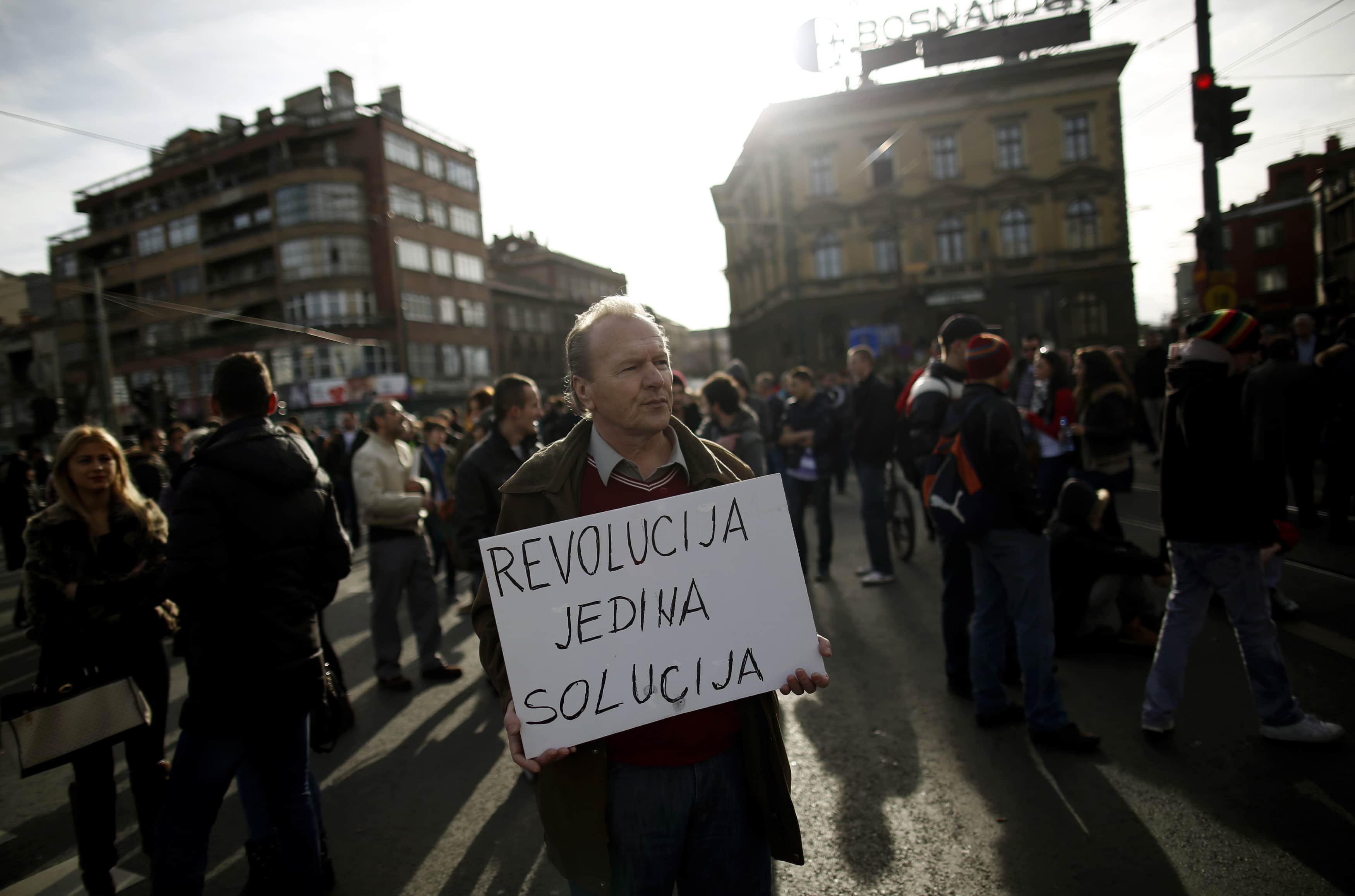 An anti-government protester holds a placard that reads "Revolution is the only solution" as protesters block Alipasina street during protests in Sarajevo, 11 February 2014., REUTERS/Dado Ruvic