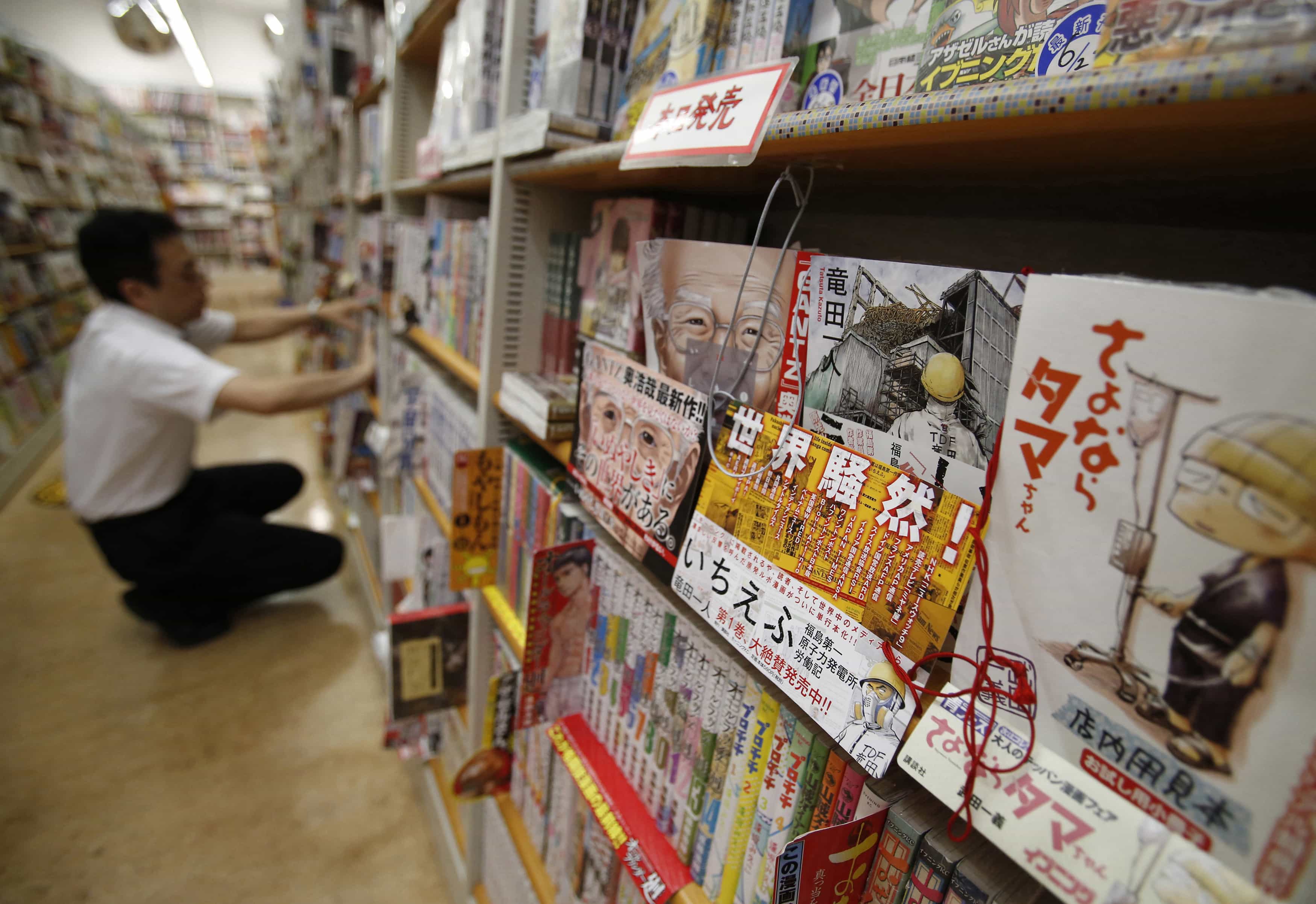 An employee adjusts manga comics at a bookstore in Tokyo, 23 June 2014, REUTERS/Yuya Shino