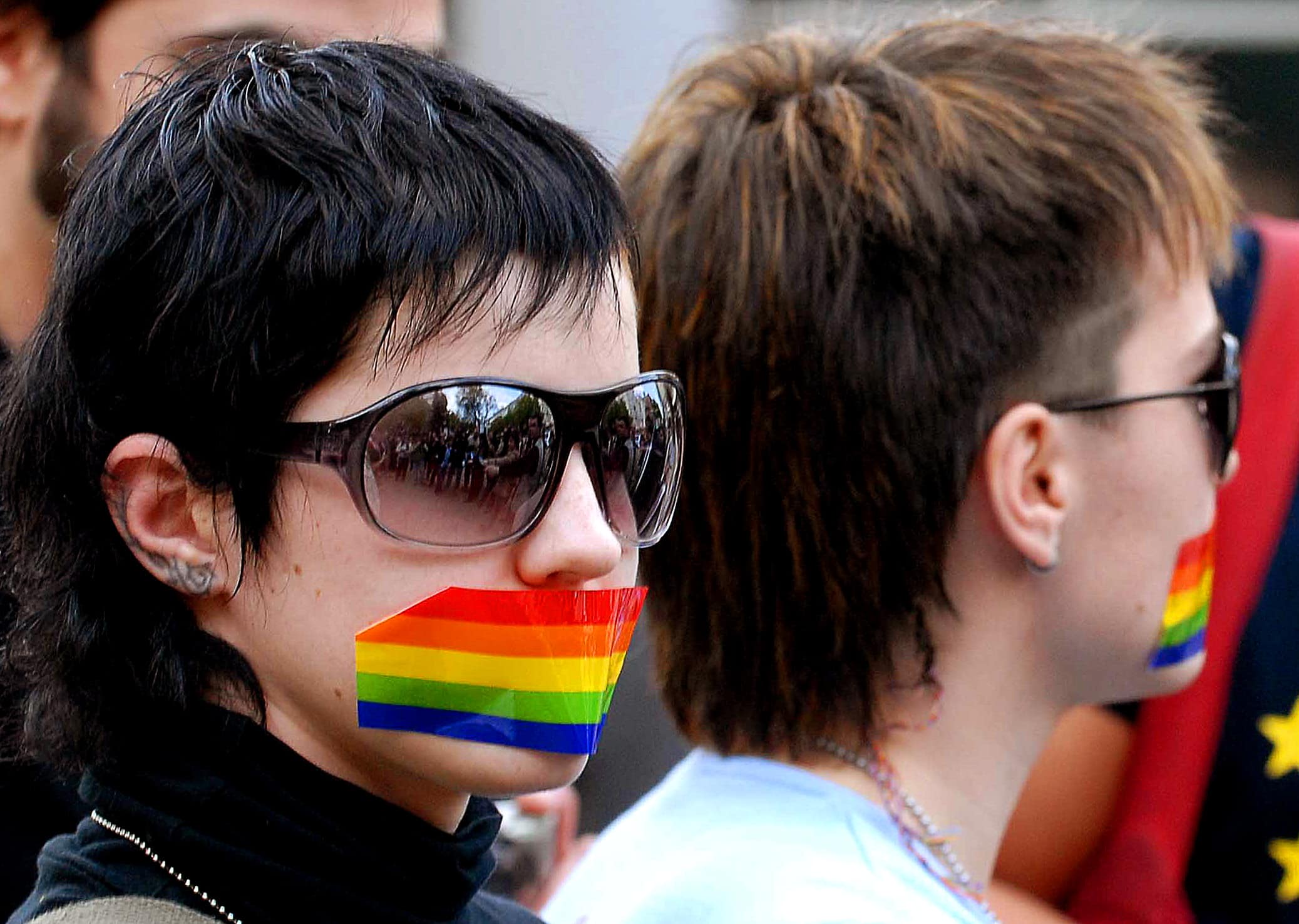 Gay rights supporters have their mouths covered with rainbow colored tape during a protest outside the city hall of Chisinau, Moldova, 27 April 2007, AP Photo/Dan Morar