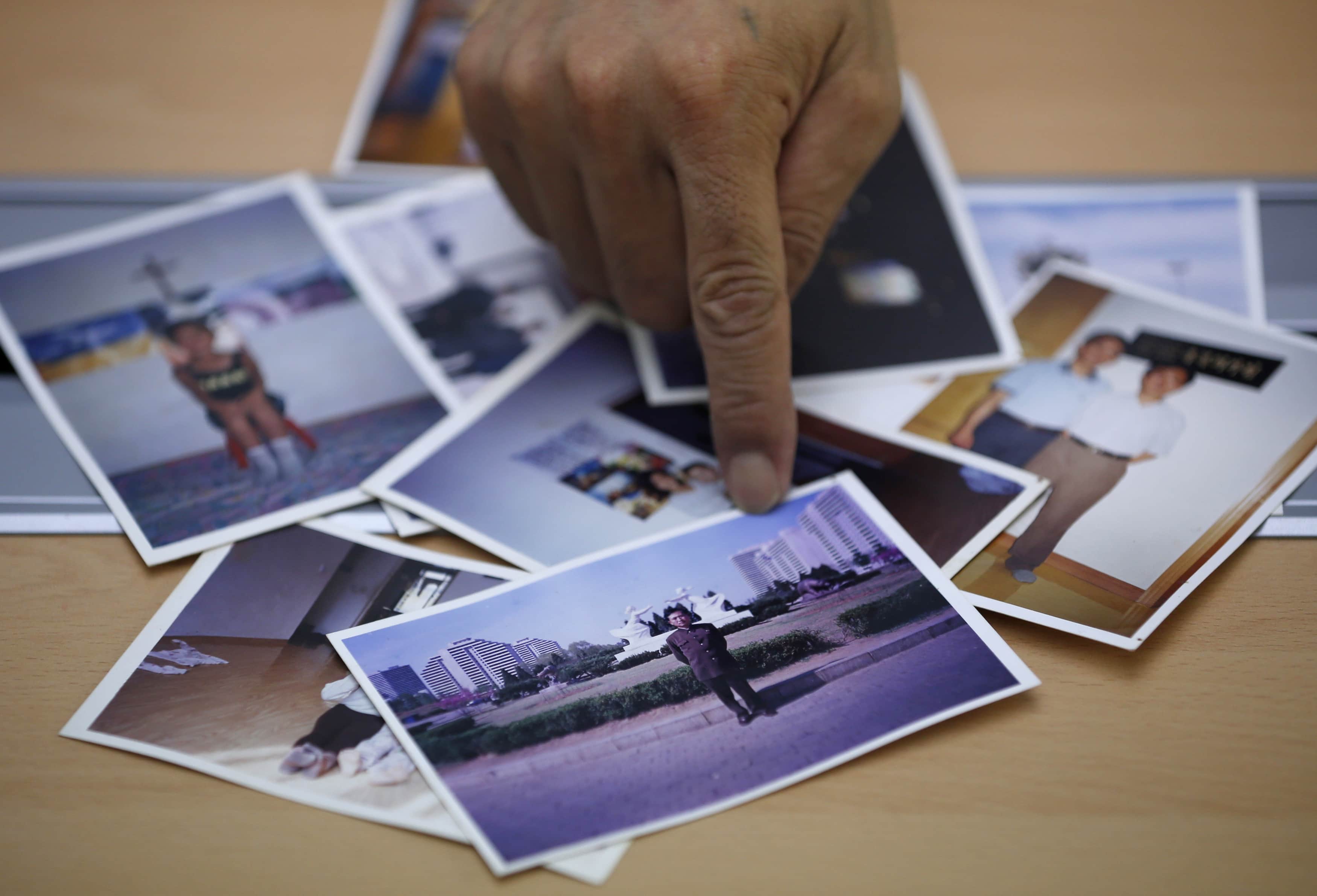 Son Jung-hun, who fled North Korea a decade ago, points at an undated picture of his brother taken in North Korea, during an interview with Reuters in Seoul, 29 July 2013, REUTERS/Kim Hong-Ji