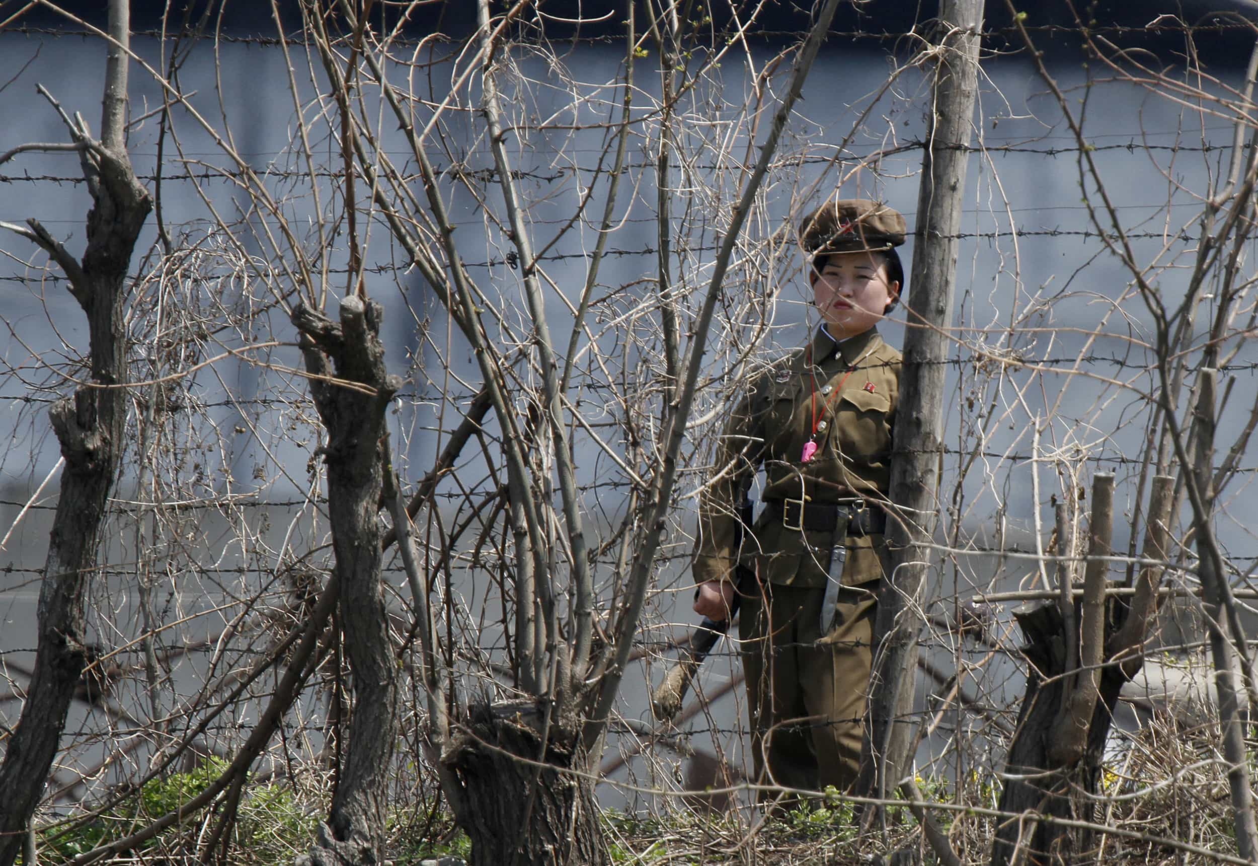 A North Korean prison policewoman stands guard at a jail, opposite the Chinese border city of Dandong, 8 May 2011, REUTERS/Jacky Chen