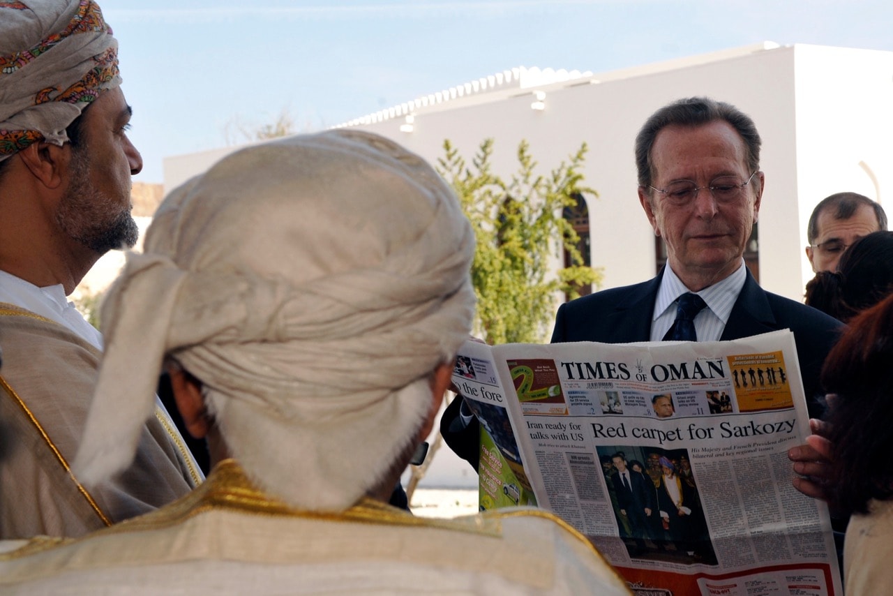 The chairman of the Arab World Institute (R), reads a newspaper outside the Maison de La France in Muscat, Oman, 11 February 2009, REUTERS/Gerard Cerles/Pool