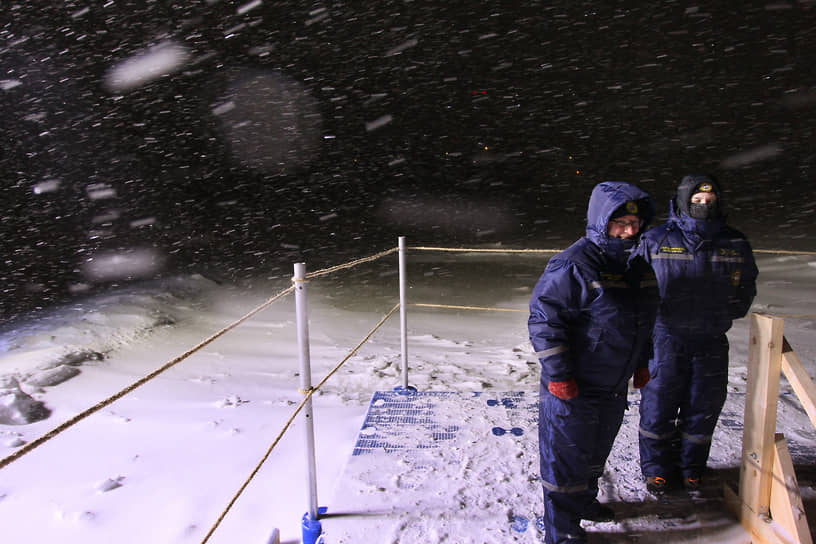 Волонтеры дежурят у купели во время снежного бурана