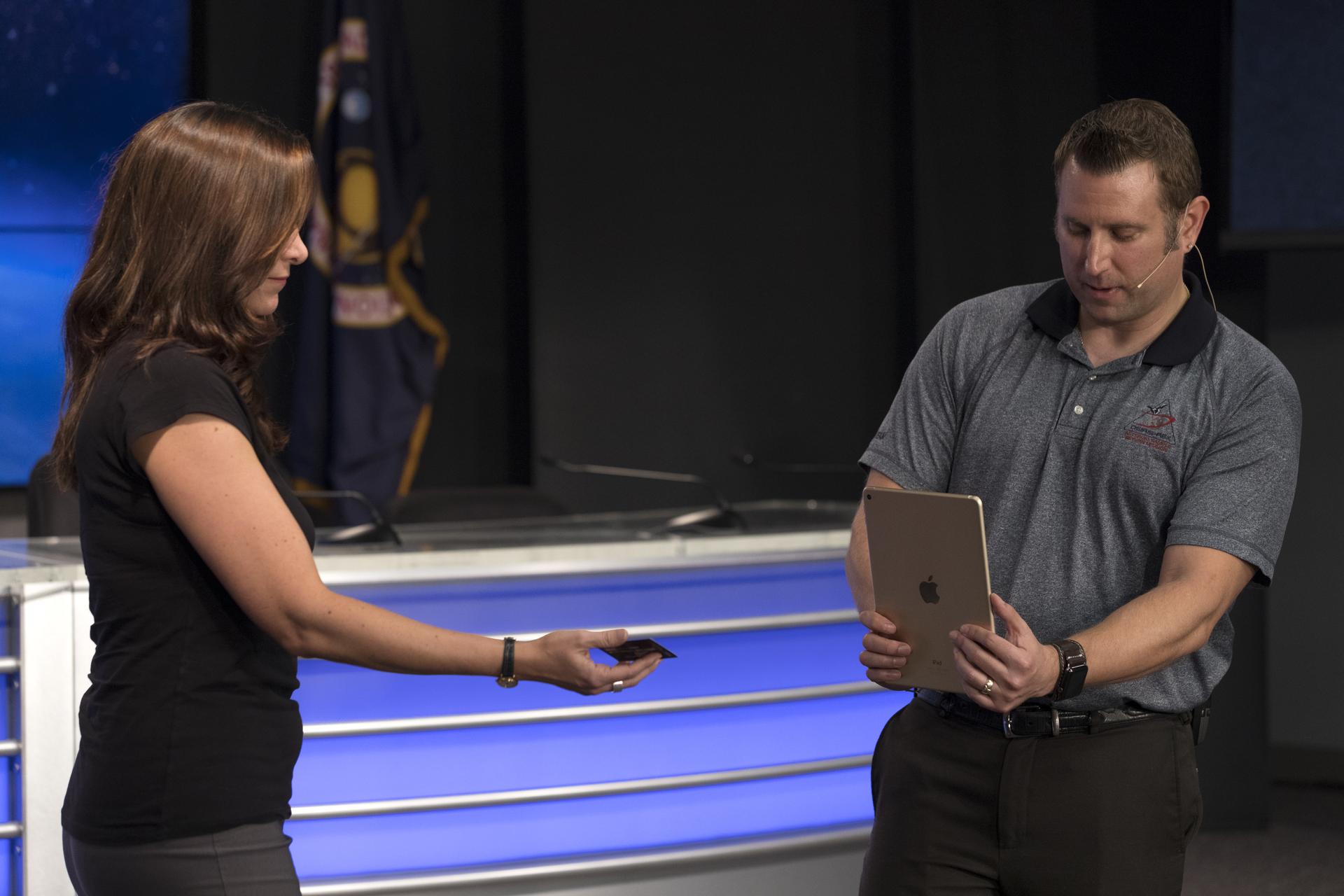 Skip Owen of NASA Launch Services, right, is demonstrating an app that can run on a mobile device such as a smartphone or tablet computer.