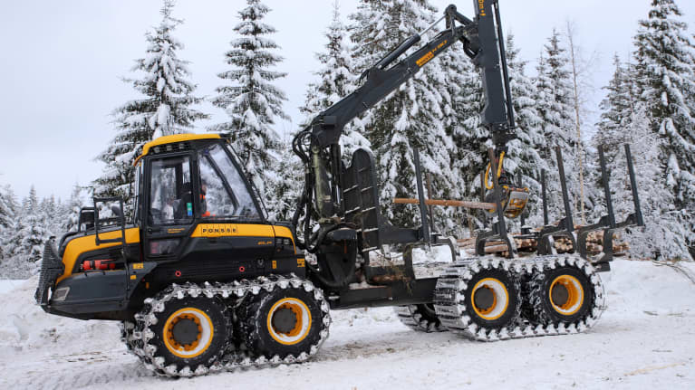 Kuormatraktori siirtämässä puita metsäkonetyömaalla.