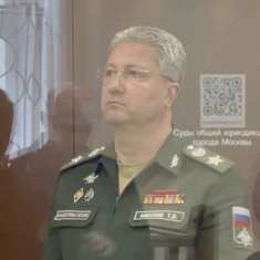 Silmälasipäinen Timur Ivanov seisoo vakavin ilmein lasin takana syytetyille tarkoitetussa kopissa oikeussalissa. Hänellä on silmälasit ja yllään puolustusministeriön vihreä univormu merkkeineen.