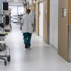Sairaalan työntekijä kävelee käytävällä.