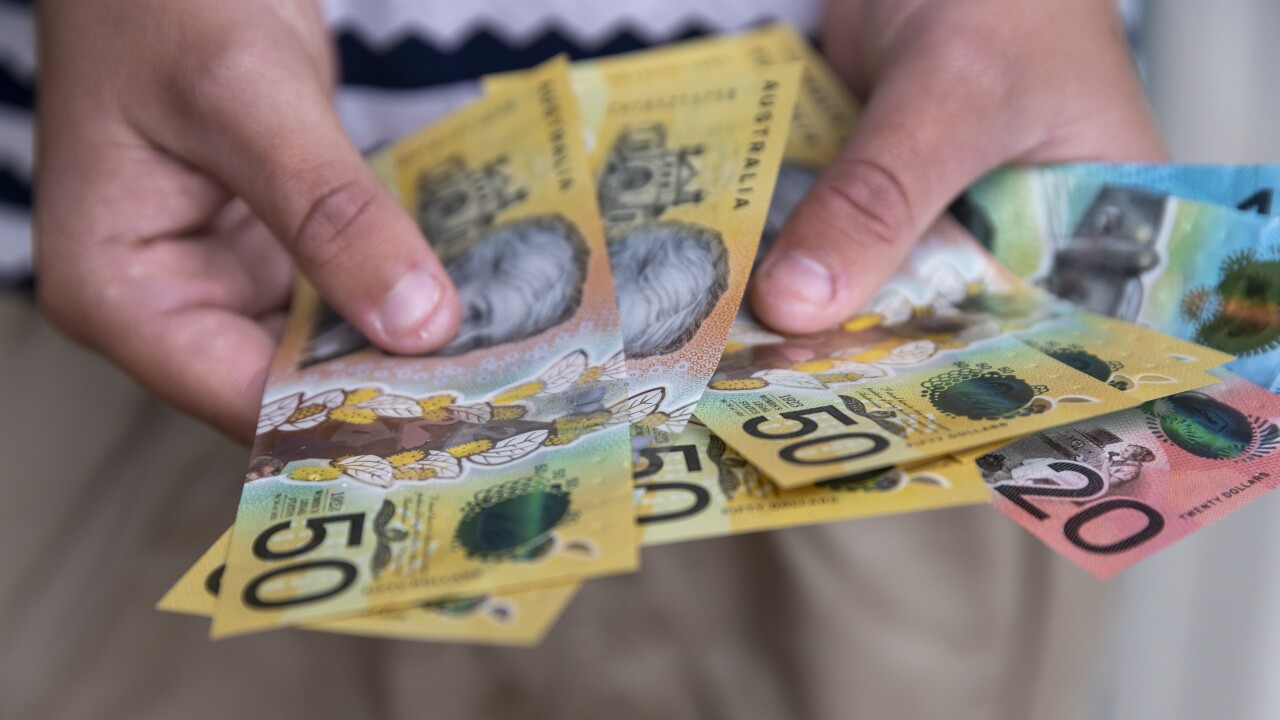 A person holding Australian banknotes.