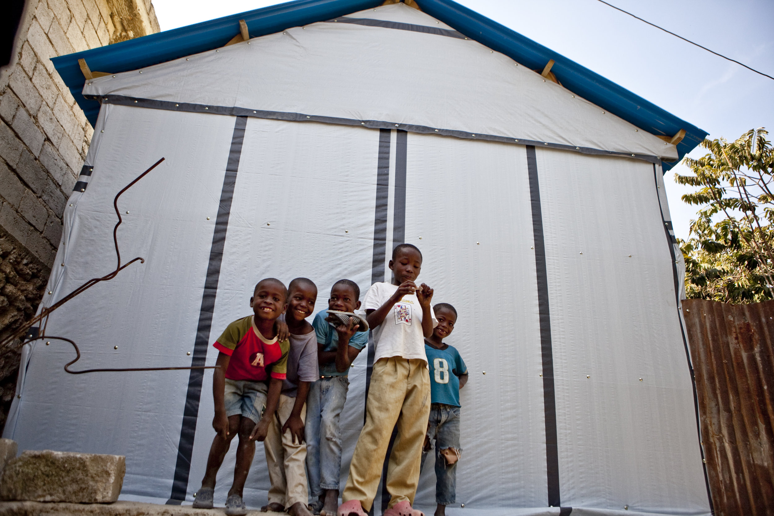 Kids in front of a transitional shelter in Astek, Carrefour. 