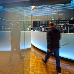 Ein Mann geht in den Handelssaal der Börse Frankfurt. Die Szene wird in einer Glastüre gespiegelt.