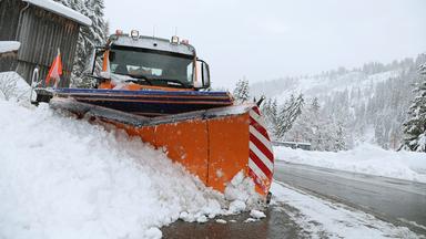 Ein Fahrzeug des Winterdienstes räumt Schnee am Riedbergpass.