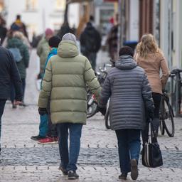 Menschen gehen in Greifswald eine Füßgängerzone entlang.