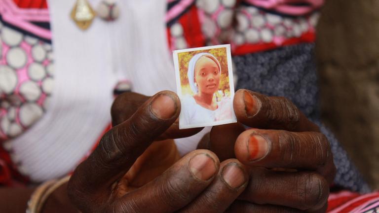 Zainabu Mala hält das Porträt ihrer Tochter Kabu, die 2014 von Boko Haram aus Chibok entführt wurde.