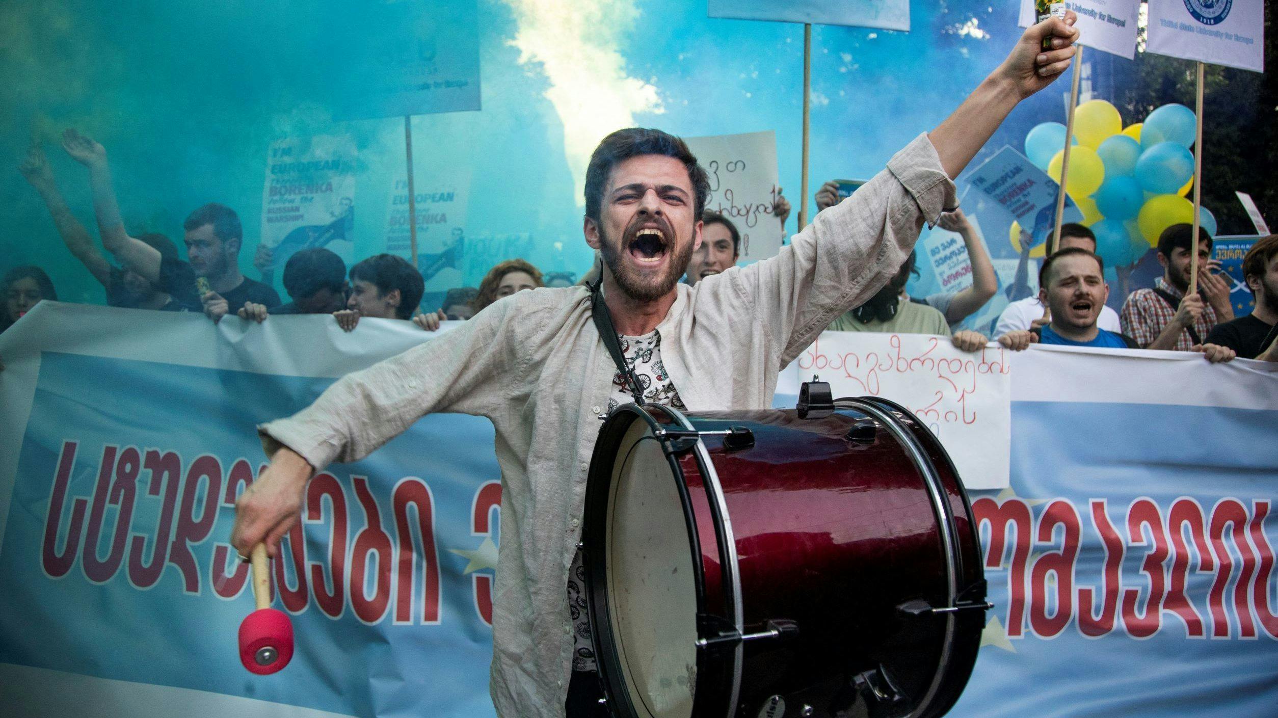 A man beats a drum and yells during a rally to support Georgia's bid to join the EU.