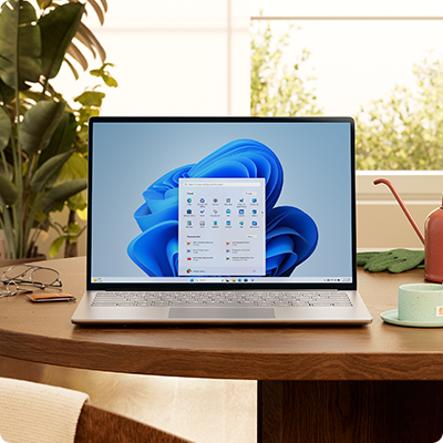 Windows 11 PC with Start menu and blue bloom