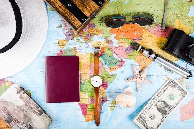Бесплатное фото Морские раковины, банкноты, паспорт и аксессуары на карте мира