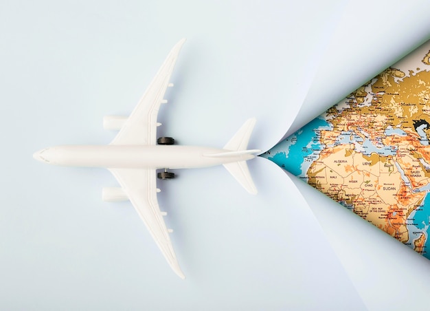 Бесплатное фото Вид сверху белый игрушечный самолет и карта