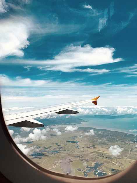 Фото Самолет, летящий в небе, виденный через стеклянное окно