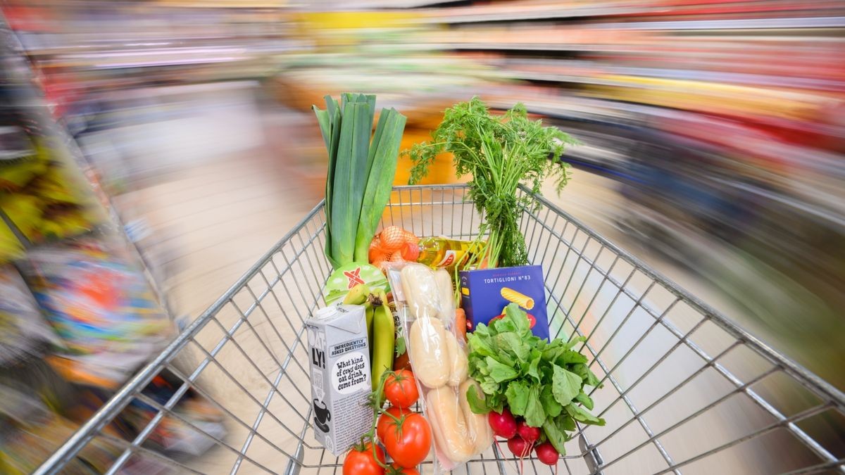 Ein mit Lebensmittel gefüllter Einkaufswagen wird durch einen Supermarkt geschoben (Symbolbild).