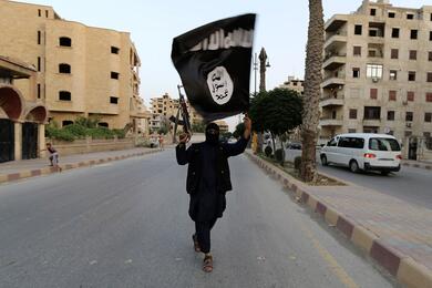 Сторонник ИГИЛ с флагом организации. Фото: Reuters