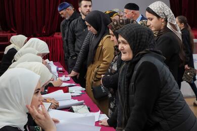 Избиратели получают свои бюллетени на избирательном участке во время президентских выборов в селе Ахмат-Юрт в Чеченской Республике, Россия. Фото: Reuters