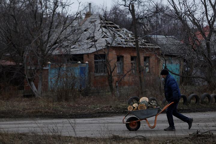 Мужчина с тачкой полной дров идет по улице Бахмута, Украина, 26 декабря 2022 года. Фото: Reuters