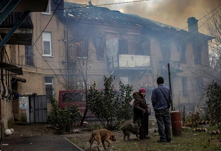 Местные жители стоят во дворе своего разрушенного жилого дома в Бахмуте, Украина, 9 декабря 2022 года. Фото: Reuters